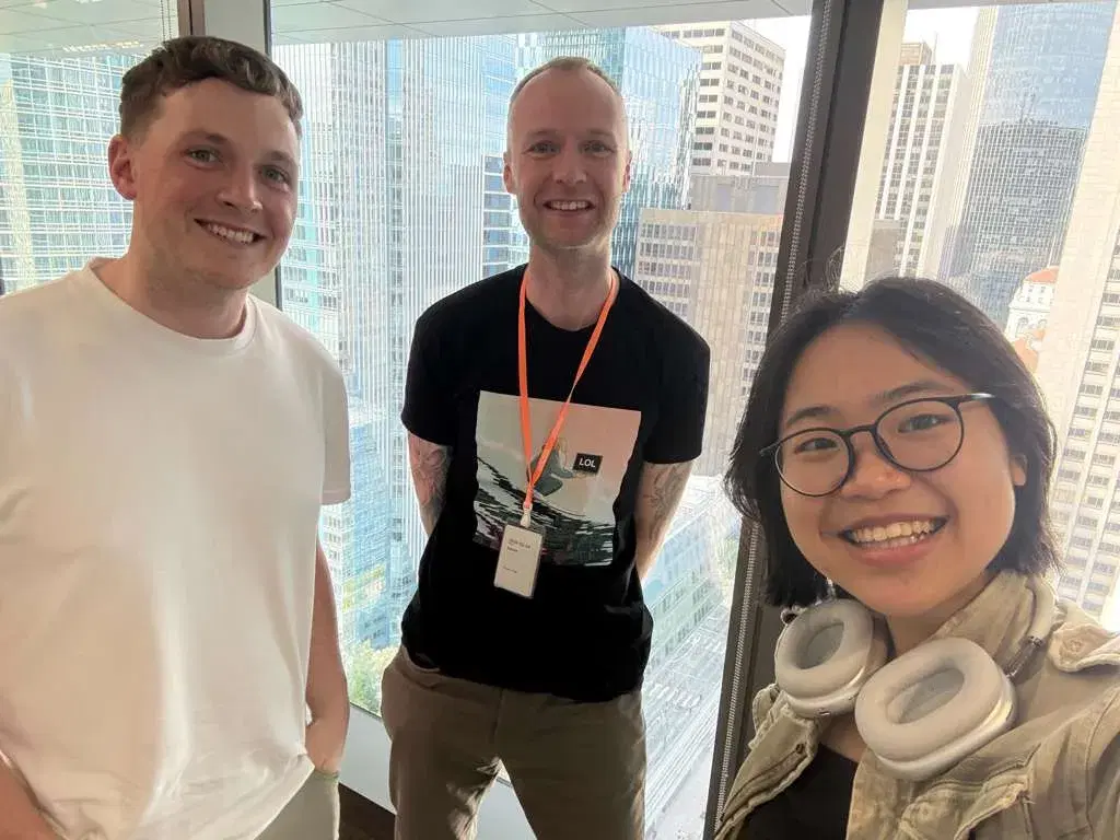 Kevin Collins visiting the Manus AI offices in San Francisco with the city skyline visible through the windows